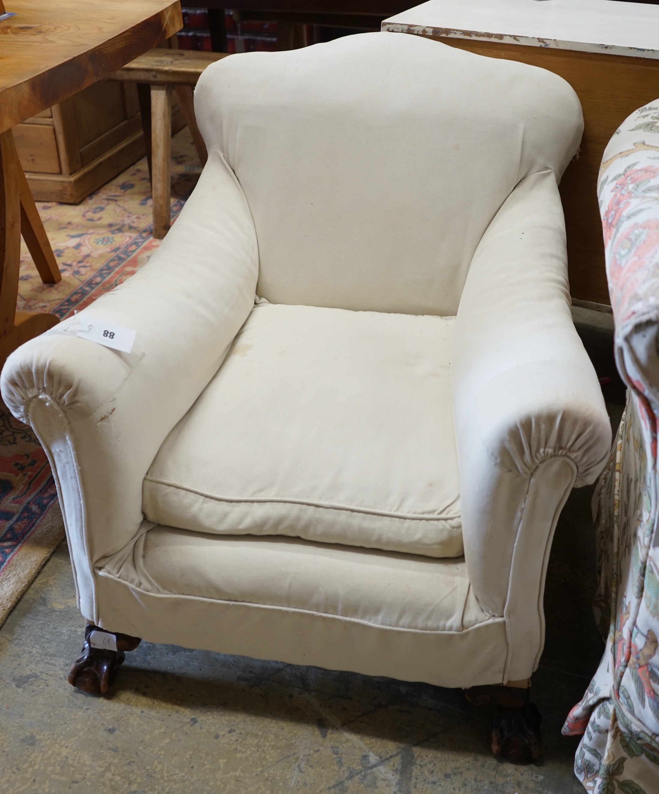 A 1920's upholstered mahogany club armchair on ball and claw feet, width 74cm, depth 86cm, height 75cm